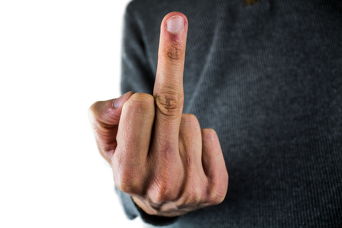 Close-up of a hand holding up a middle finger.