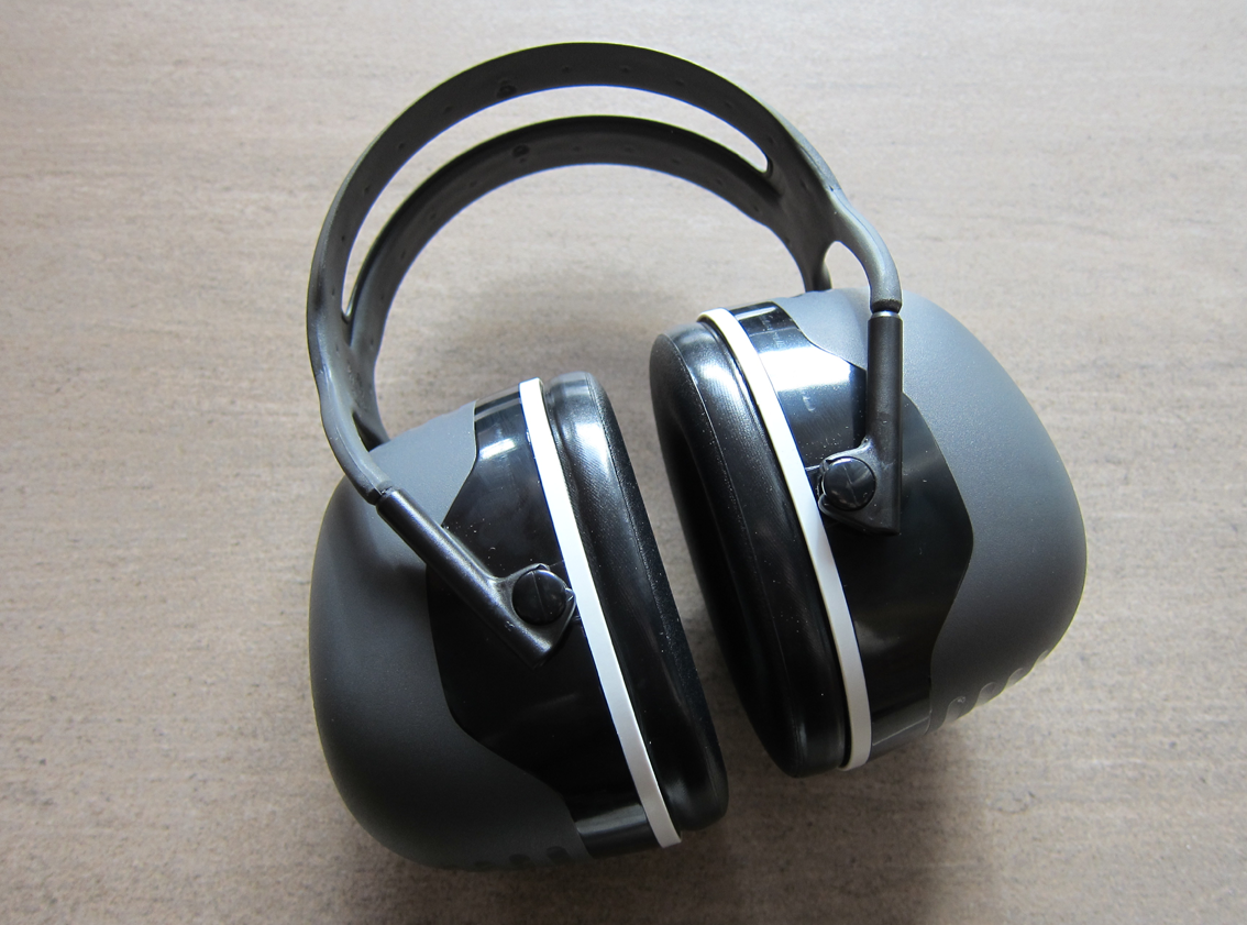 Grey, black, and off-white ear defenders with a plastic twin headband and very thick shells.