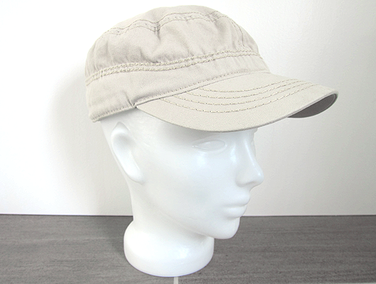 White background, grey floor, white glass head wearing a beige canvas baseball cap.